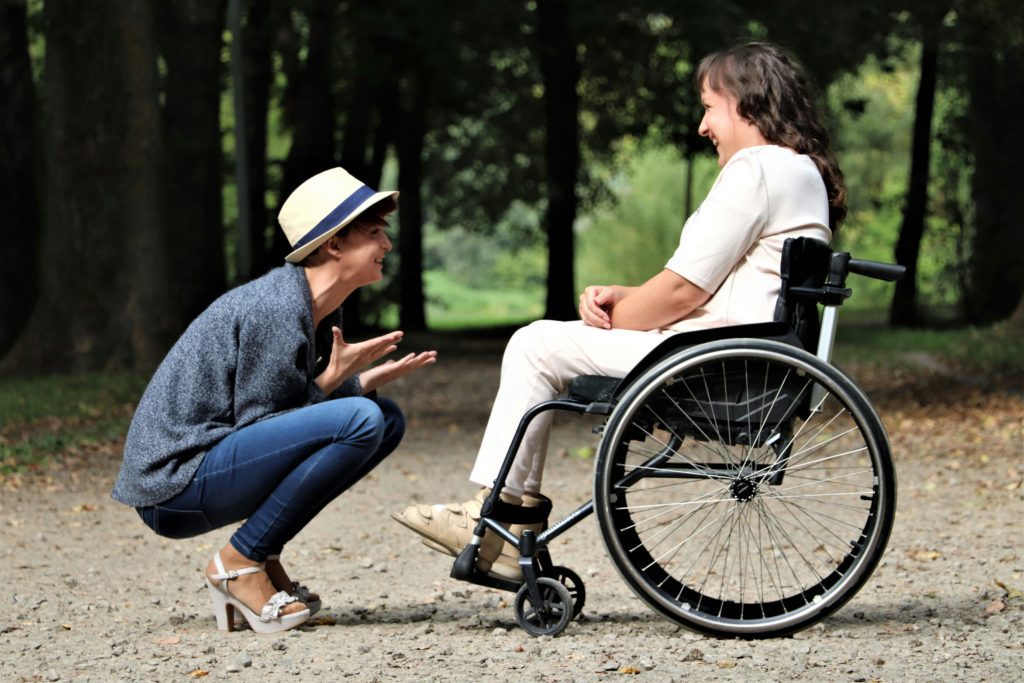 Woman speaking to person in wheelchair