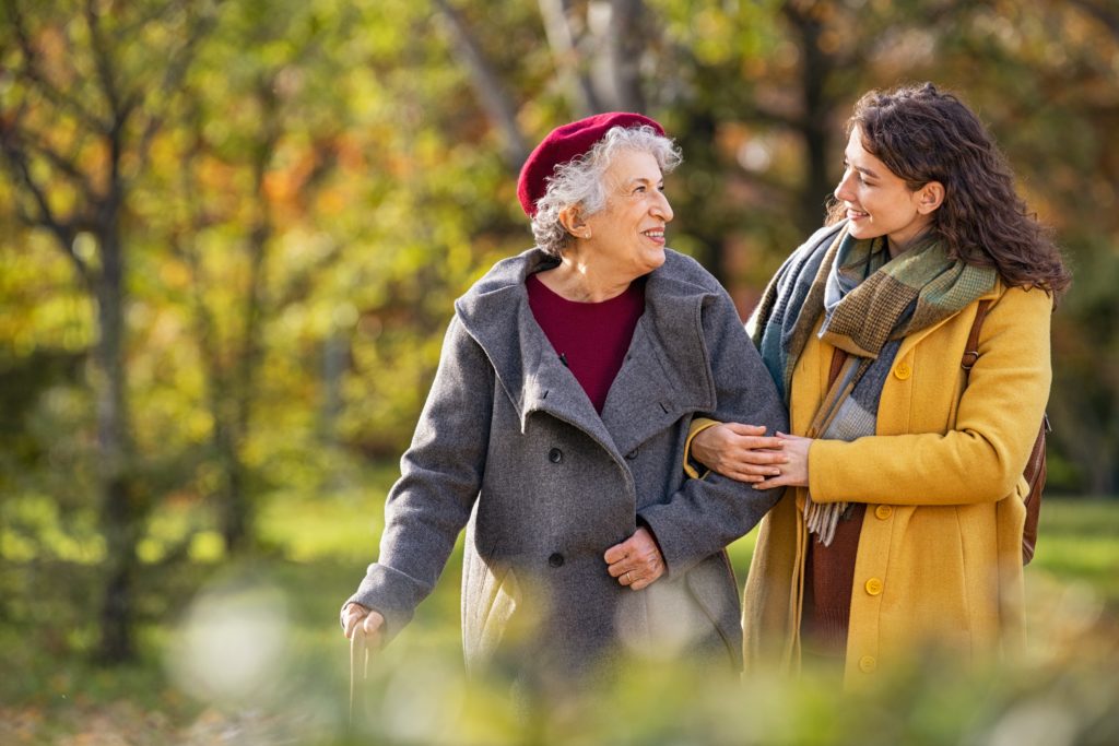 Two women walking in autumn park.
